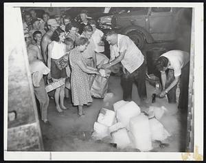 Dry Ice for Family Freezer- Residents of Southbridge, where floods cut off all power, line up for dry ice to preserve foods at dispersal center of the Catholic Charities. Tons of dry ice were moved to all devastated areas.