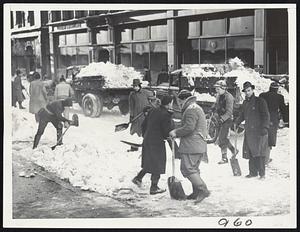 A Downtown Shopping Street--City of Boston workmen pictured early this morning clearing a downtown street for auto and foot traffic. Snow here has been hardened by yesterday's traffic and much of it is frozen solid.