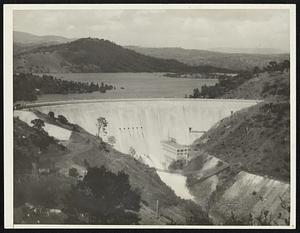 Thirty Year Fight Won Four Million Dollar Irrigation Dam Completed. The fight that has been going on for some 36 years has finally been won by the farmers of Tuolumne County, California. The new Don Pedro dam near Turlock has been completed. Some of the richest country in the State of California is in the Turlock and Modesto districts. For 36 years the farmers have been hampered by lack of sufficient water supply for irrigation purposes. The new dam was just recently dedicated and farmers claim that it will add millions of dollars annually to their crops. The new dam will supply nearly 200,000 acres with water for irrigation. The dam cost nearly $4,000,000 and is the highest dam in the world, being 283 feet high. The dam gets its water from the Tuolumne river and impounds 290,000 acre feet of water. Photo shows general view of the new $4,000,000 Don Pedro dam at Turlock, California.