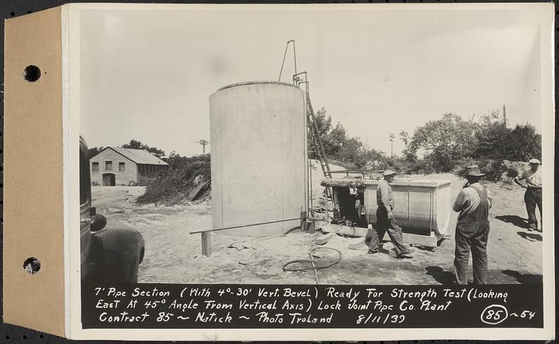 Contract No. 85, Manufacture and Delivery of Precast Concrete Steel Cylinder Pipe, Southborough, Framingham, Wayland, Natick, Weston, 7 ft. pipe section (with 4 degree 30 foot vertical bevel) ready for strength test, looking east at 45 degree angle from vertical axis, Natick, Mass., Aug. 11, 1939