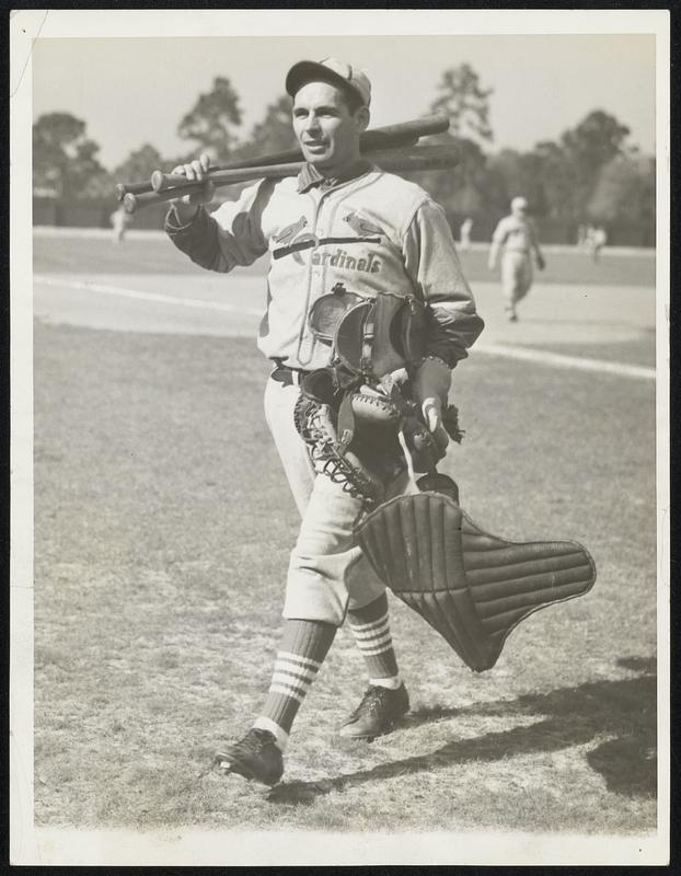 Card's One-Man Baseball Team. Daytona Beach, Fla., Mar. 3 -- Dominic J. Ryba is listed as a pitcher with the St. Louis Cardinals. But this versatile young man has been known to catch, pitch, play in the infield and in the outfield -- All in the same game. He is shown here at the card's training camp with some of the equipment he'll need if he decides to repeat the stunt.