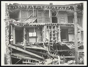 Quake Cuts House In Two -- A house in Compton, Calif., which was cut in two by the earthquake of March 10. The room in center shows a chair and mirror still in position, while the rest of the room is nothing but shambles at the bottom.