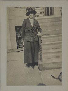 Unidentified woman standing next to steps, 115