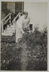 Unidentified woman watering garden, 119