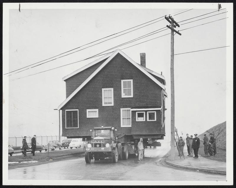 A House In The Middle Of The Road- Movers were stymied yesterday, while shifting this house from Waldemar avenue to Ashley street, East Boston, by electric wires across the McClellan highway at Boardman street. traffic was made two-way on south-bound lane of highway during delay.