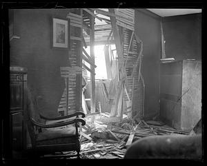 A hole on the side of a house, possibly from an explosion