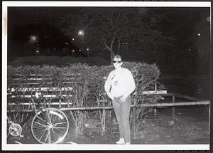 Young woman standing in a courtyard or park at night
