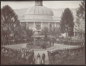 A formal parade or official political event in outdoor square in front of domed building with eagle crest