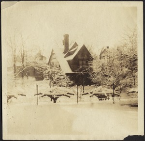 View of wooden house with peaks and gables in snow