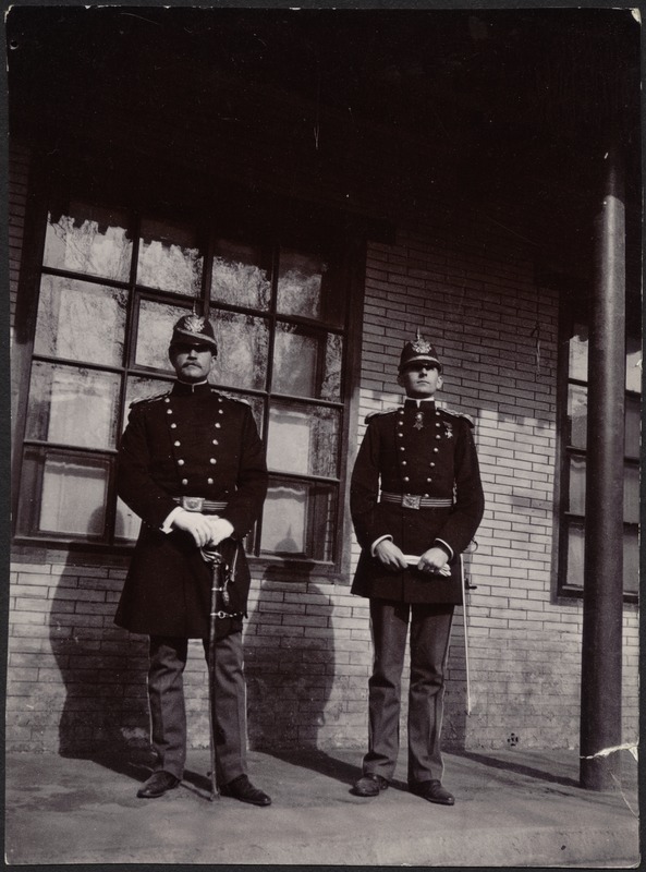 Two unidentified German officers standing in front of brick building