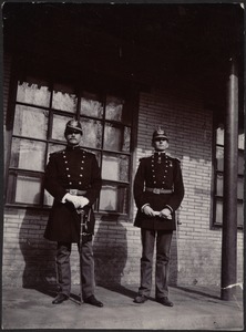Two unidentified German officers standing in front of brick building