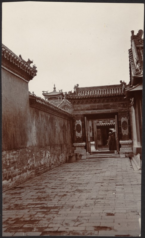 Stone and brick walkway; two Chinese men standing in doorway entrance