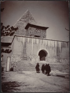 Group of Chinese men, possibly monks, walking up steps to temple entrance