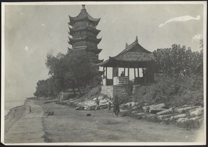 Pagoda temple and shrine near sea wall; man with walking stick and children on pathway