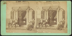Two men and two women seated at the entrance of their cottage