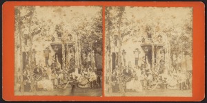 Group portrait of people in front of cottage, with trees planted in yard