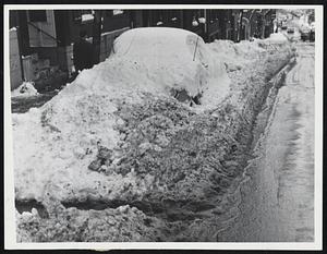 Trouble Either Way -- If the owned of the car beneath this Mt. Vernon street mound doesn’t dig it out, he faces suspension of license for parking illegally. If he decides to move it, he’ll have trouble digging it out.