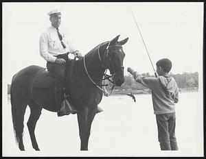 Officer Paul Simonettie Dec 16 with horse Shawn, Mike Dello Russo 7, yrs, Roslindale showing fish to the horse that he caught.