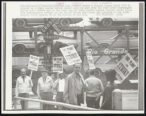 Detroit: United Auto Workers picket a General Motors plant 9/15 in Detroit as a train passes behind loaded with new cars from the Ford Motor Company. The United Auto Workers are in the first day of their strike against General Motors 9/15. Some 350-thousand workers in the United States and Canada are involved in the walkout, the third against GM in the history of the UAW. Labor Strike. Auto Workers.