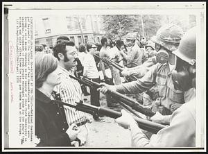 Bayonet at the Throat--National Guardsmen put bayonets to the throats of two demonstrators who refused to move during a wild melee Thursday on the campus of Ohio State University in Columbus. Thousands of young people exchanged rocks for the Army's tear gas attack and quite often threw the tear gas bombs back at the troops.