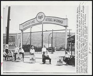 Pickets Block Steel Plant Entrance- Shirtsleeved pickets relax on folding chairs at main entrance of U.S. Steel's Duquesne steel works here today after United Steel Workers went on strike against the nation's steel companies a minute after midnight Plants here have been working 'round the clock and on Sundays.