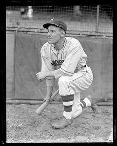 A Brooklyn Dodger, possibly Ray Benge, kneeling with a baseball bat