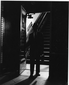 Man in shadow exiting 921 Boylston Street building on Boston campus