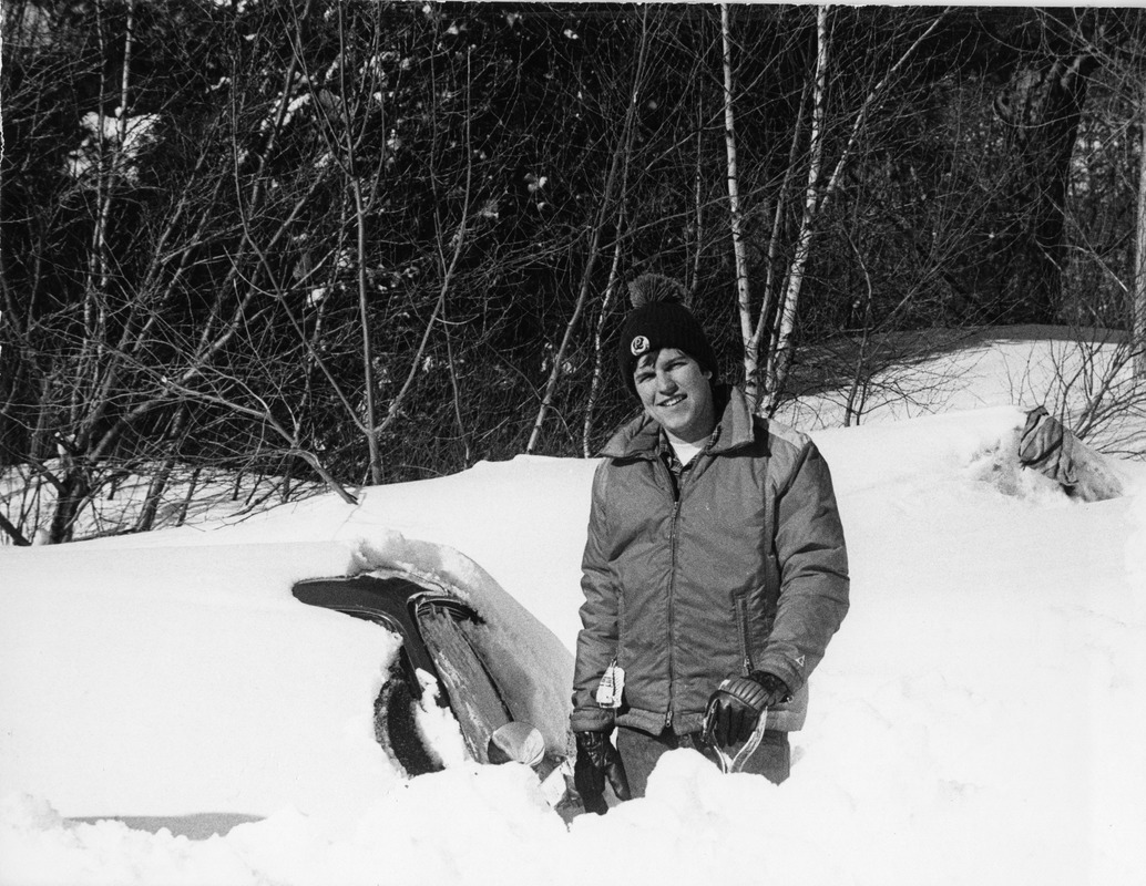 Student poses near car buried in snow during Blizzard of '78