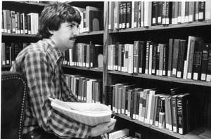 Library worker doing shelf reading of books