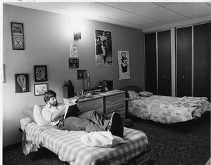 Student reads book in dormitory bed