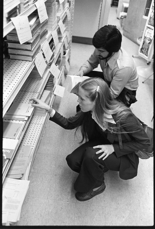 Students looking at textbooks in campus bookstore