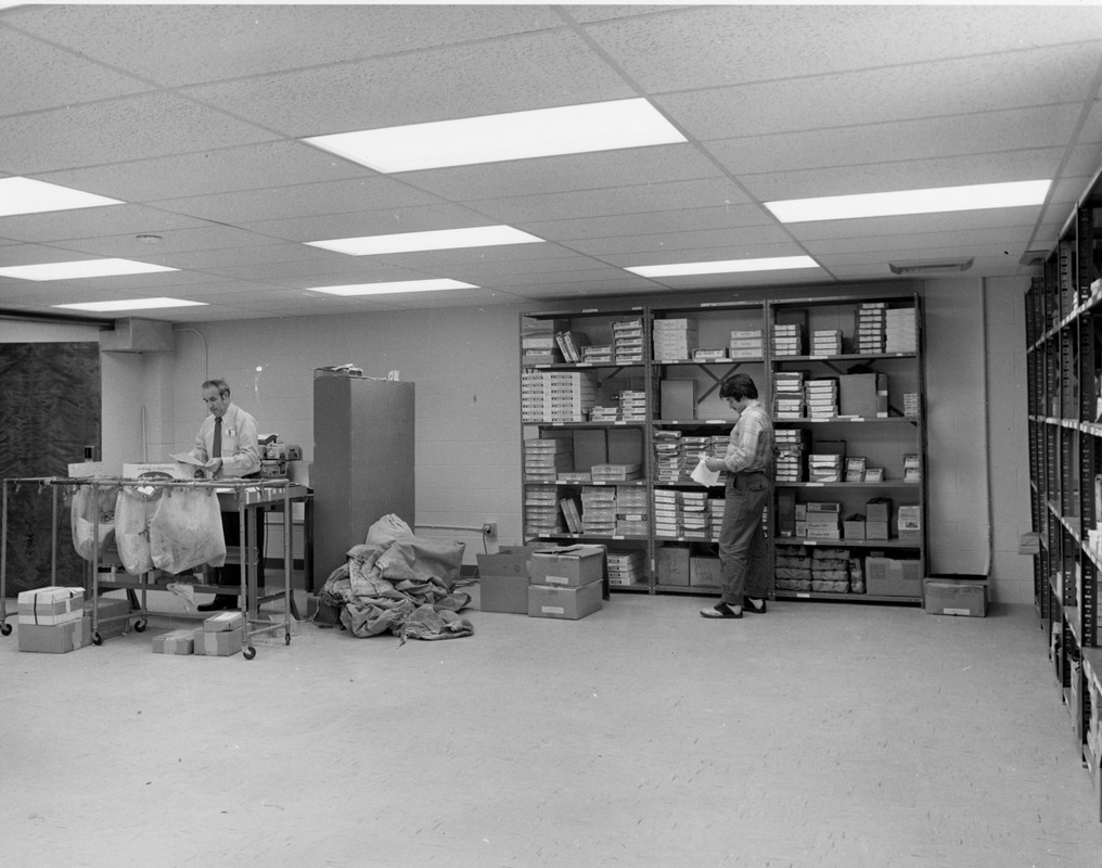 Employees sort mail in mail room