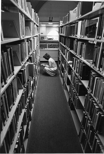 Person looks for book in Library stacks