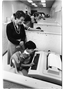 Adult with child at word processing machine