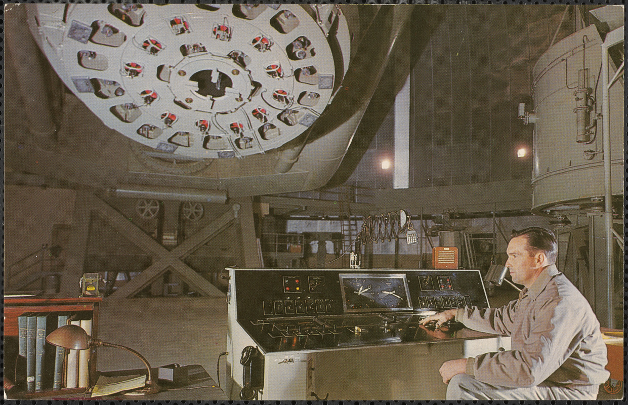 Palomar Mountain, California, 200" observatory - assistant seated at control panel with the great mirror in the background