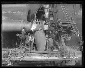 Men working on installing a large boat propeller