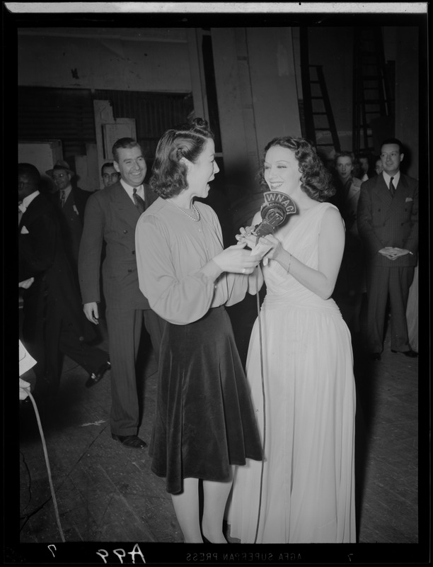 Ruth Moss of WNAC interviewing an unidentified woman in a gown backstage