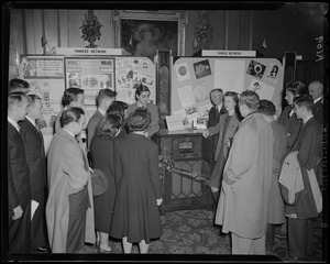 Group of people gathered around Stromberg-Carlson FM radio in front of Yankee Network display