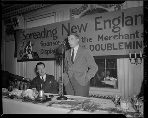 Charlie O'Rourke addressing Spreading New England's Fame banquet at WNAC microphone as Linus Travers watches