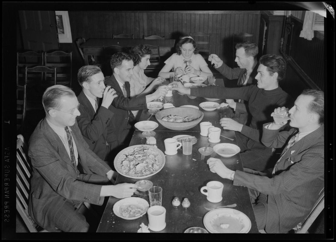 Eight people eating a meal