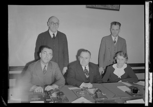 Five unidentified people posing behind a desk