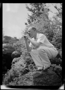 Photographer crouching on rock