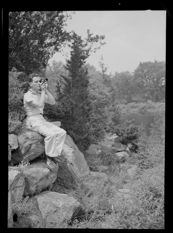 Photographer seated on rocks in the woods