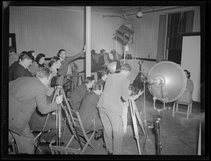 Multiple photographers taking a portrait in a studio, possibly a photography class