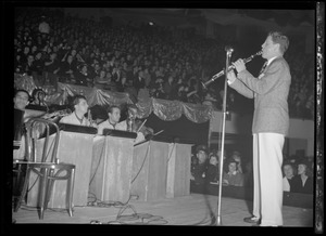 Man, possibly Rudy Vallée, playing the clarinet with a band on stage