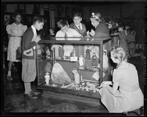 Children looking at dolls in display case