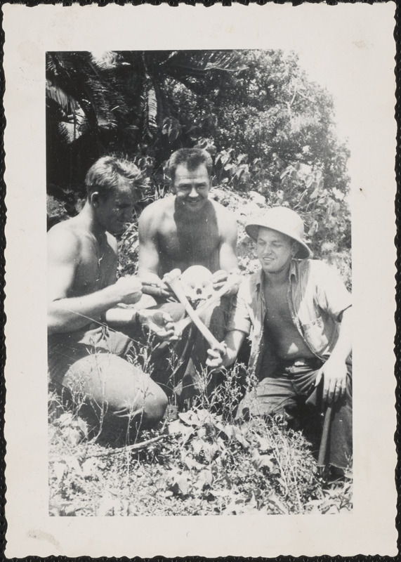 Appears to be U.S. Sailor hold human skulls