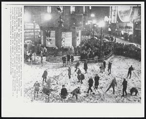 New Year Revelers In London Snow - Amid falling snow, London revelers welcome the new year with a snowball battle in Piccadilly Circus early today. Other celebrants stand around the statue of Eros in background which is boarded up for the occasion. Howling blizzards struck Britain again with the coming of the new year.