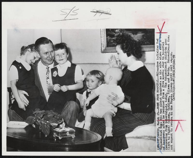 Home From Hospital -- Milwaukee infielder Red Schoendienst hugs his two oldest daughters as his wife wipes away tears of happyness after he returned from a five month stay in hospital recovering from tuberculosis today. The Schoendienst children are- left to right) Coleen, Cathleen, Eileen and Kevin. Schoendienst does not expect to return to the Braves lineup until next season.