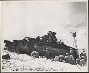 Marine infantrymen carry on the right from the shelter of an amphibious tractor which brought them ashore